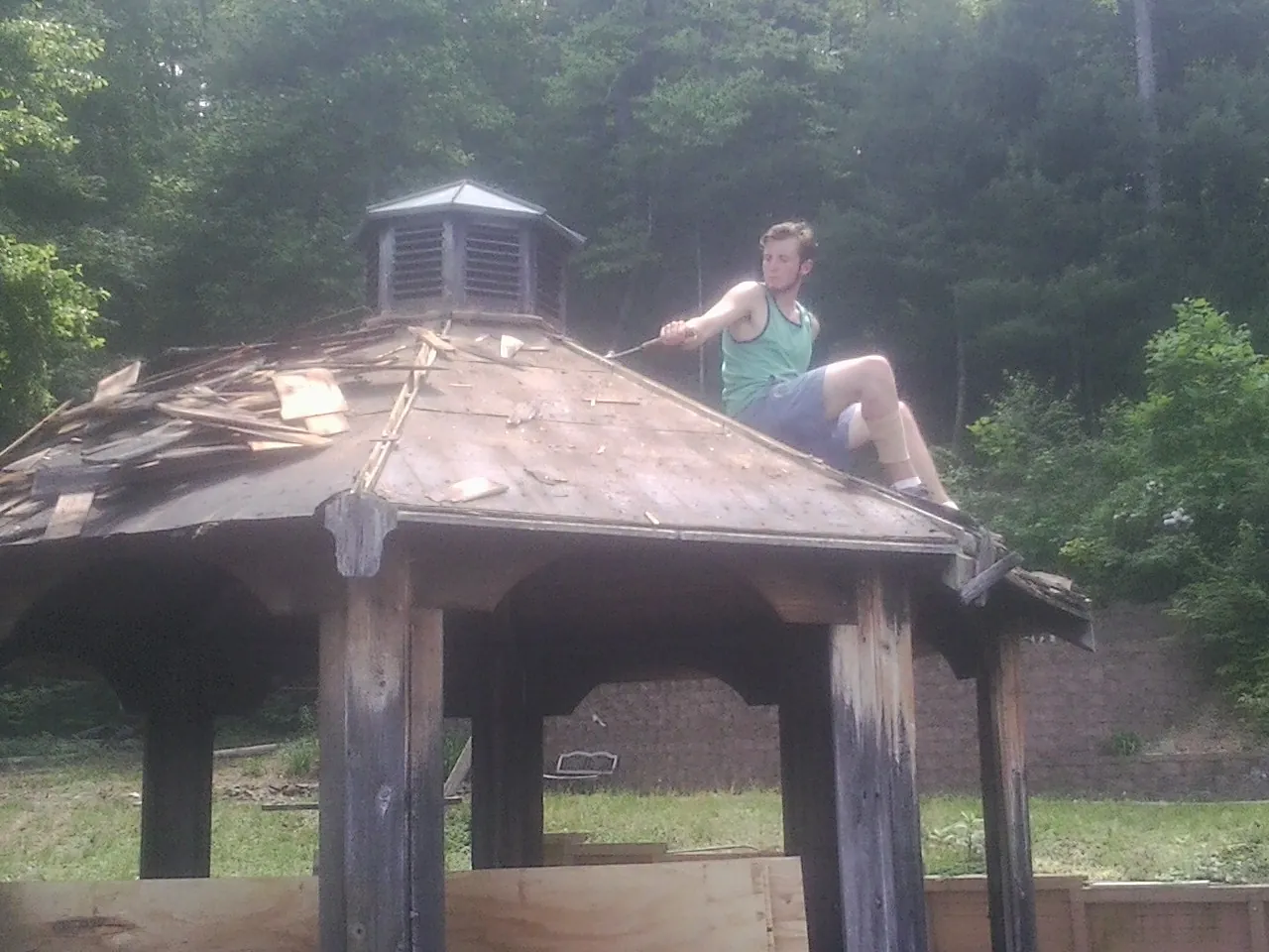 Tearing the old roof off a wooden gazebo before new shakes in Pleasantville