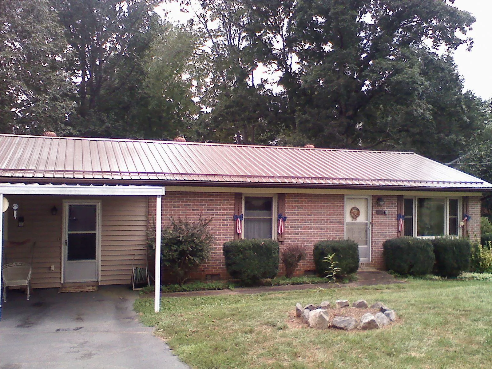 Bronze metal roof and carport on a brick ranch home — Roof Repair work by our crew in Pleasantville
